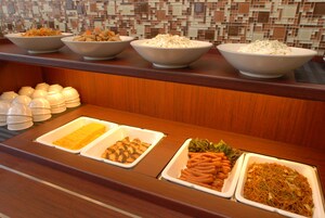 Un bufé con diversos platos, incluyendo pasta, verduras y otras preparaciones culinarias.