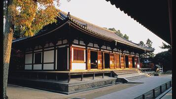 Um edifício japonês tradicional com telhado telhado, colunas de madeira e base de pedra.