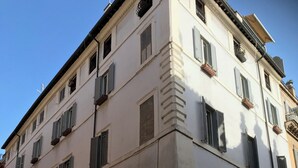 A multi-story building with a white facade, multiple windows with shutters, and a no-entry sign. - Rome, Historical Center, Via Giulia: unique, elegant, bright, 2 bedrooms, 2 bath (Roma)
