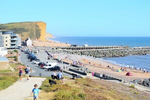 A coastal town with a promenade, beach, and cliff. - Apartment with stunning Sea View (Bridport)