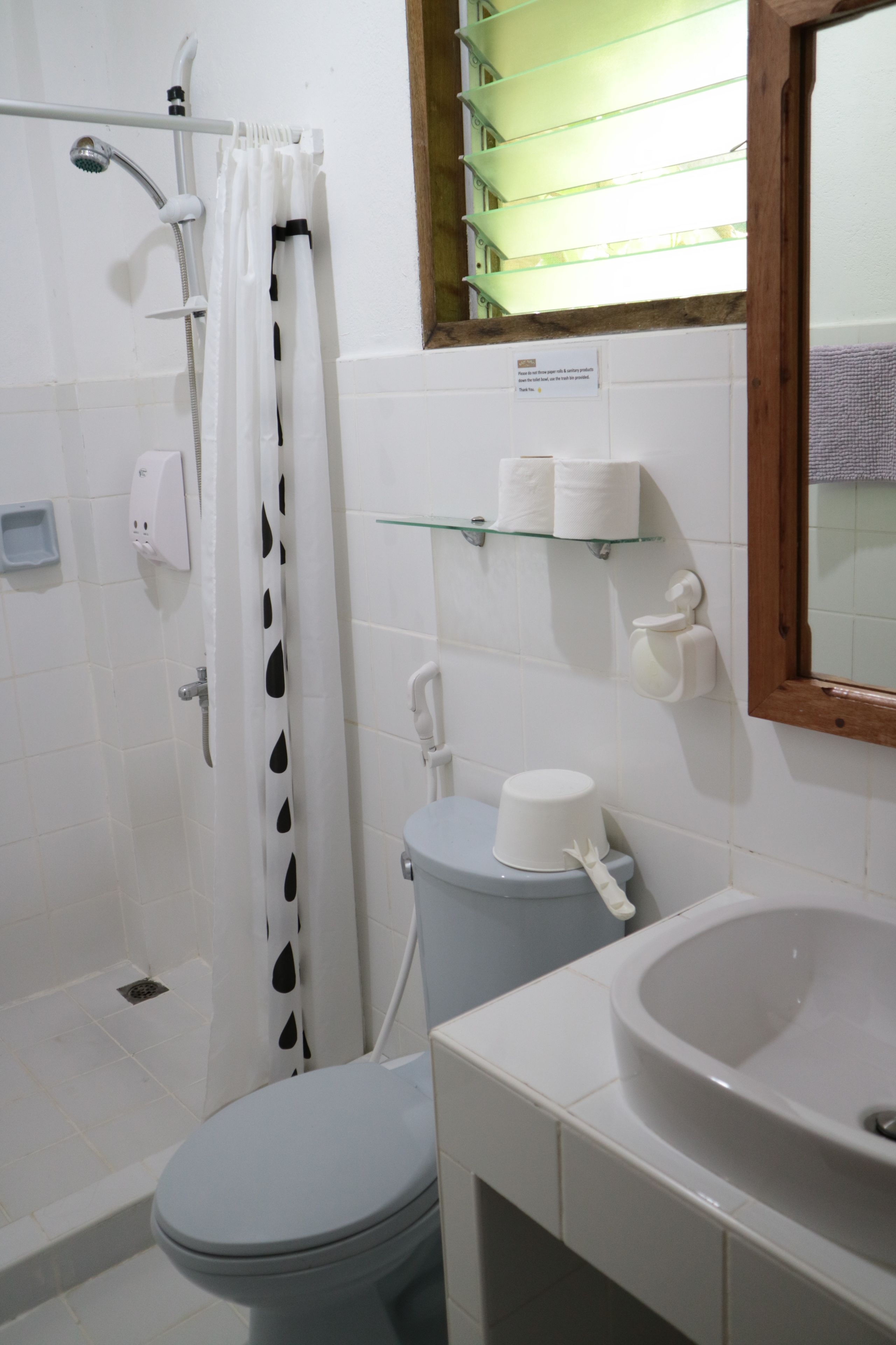 Un baño con ducha, inodoro y lavabo.