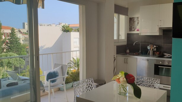 A modern kitchen with a built-in oven and a dining area with a table and chairs.