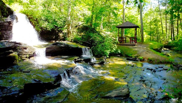 A waterfall in a forest with a gazebo. - Cozy Log Cabin In Riverbend, Lake Lure North Carolina (Lake Lure)