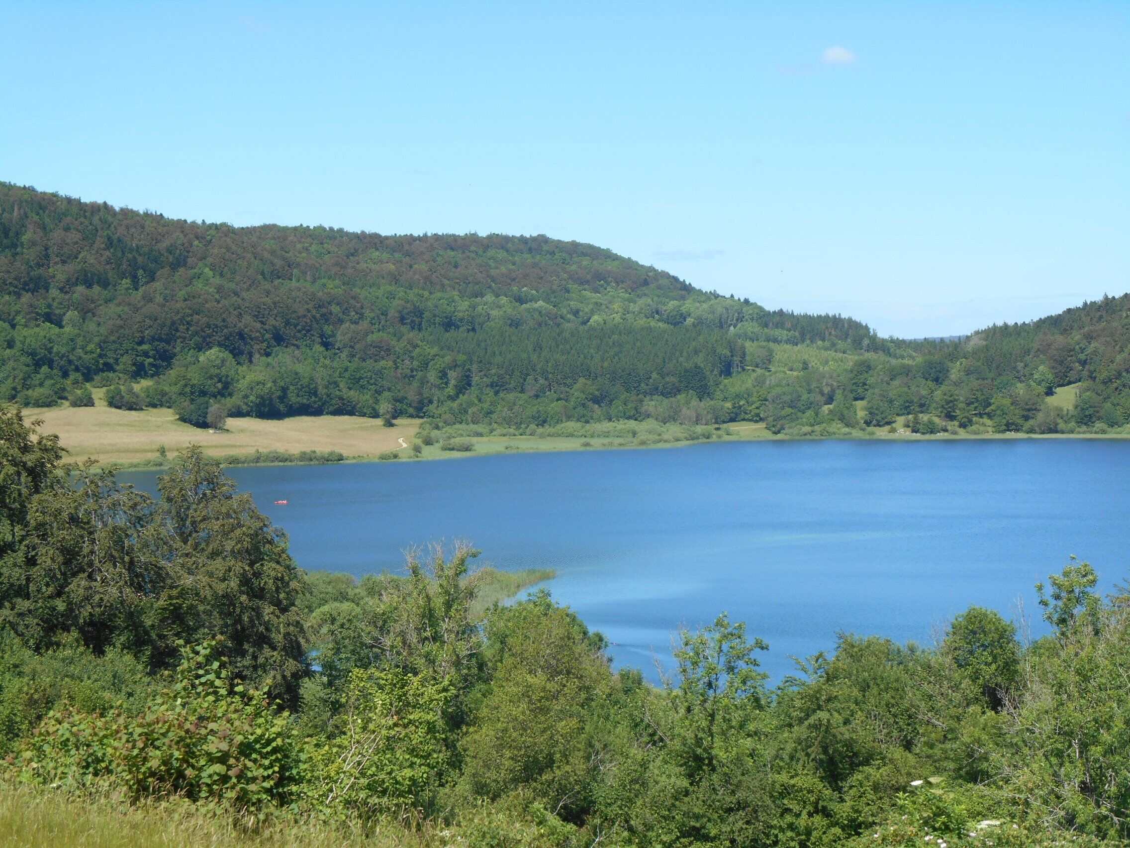 A lake surrounded by forested hills.