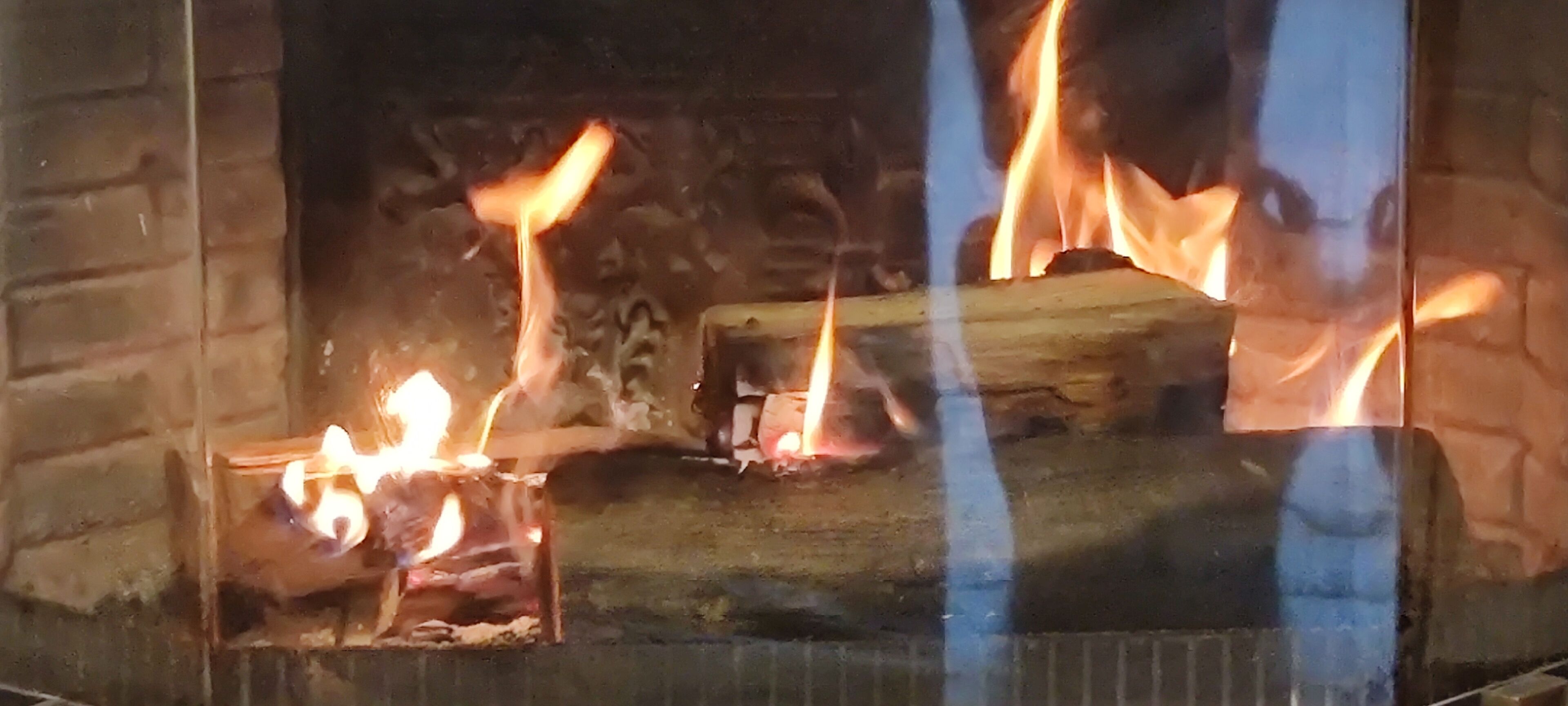 A fireplace with burning logs and flames.