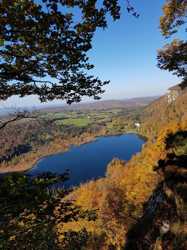 A lake surrounded by autumn-colored trees and hills.