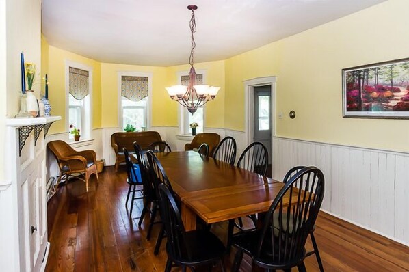 A dining room with a wooden table and chairs, a chandelier, and a painting on the wall. - Fishing & Campfires!! 40 acres on Battlefield! (Gettysburg)