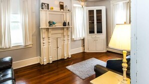 A room with a fireplace, a cabinet, a lamp, and a leather chair.