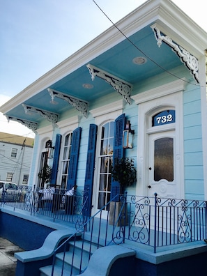 Un edificio con facciata blu, decorazioni bianche e il numero 732 sulla porta.