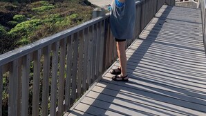 Una pasarela de madera que conduce a una playa con cielo despejado.