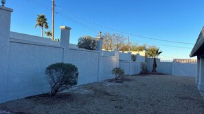 A residential area with a white wall, a small tree, and a clear sky. - Lake House to RELAX and Have FUN!!  FREE Wi-Fi. (Lake Havasu City)