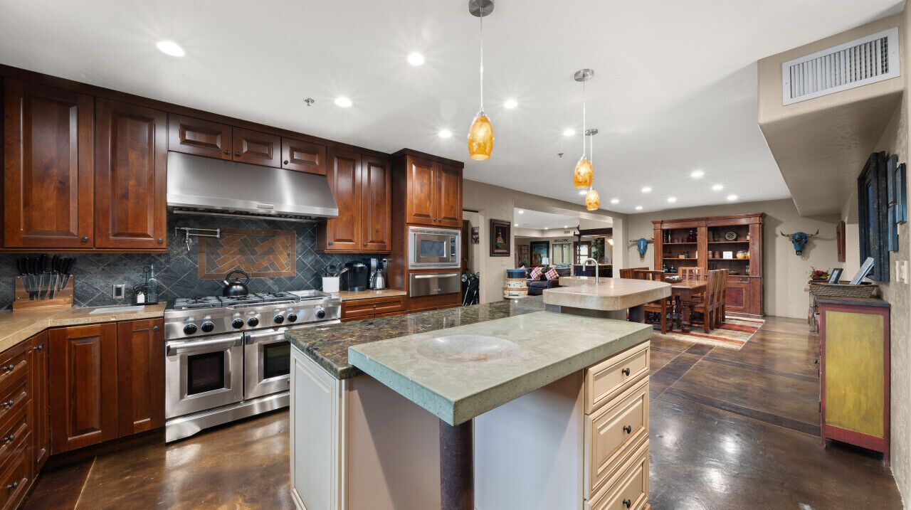 A modern kitchen with wooden cabinets, stainless steel appliances, and a large island.