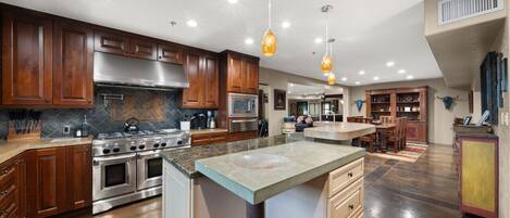 A modern kitchen with wooden cabinets, stainless steel appliances, and a large island.