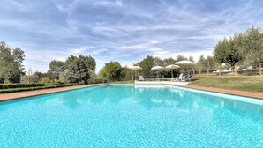 A rectangular swimming pool with clear blue water, surrounded by a wooden fence, and shaded by umbrellas. - Tuscan Apart for 4/5 persons, WIFI, AIR-CO, SW-POOL, all comforts in the country (Montespertoli)