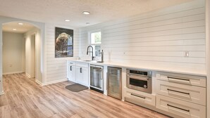 A modern kitchen with white cabinetry, stainless steel appliances, and a wooden floor. - Breathtaking View with an Indoor Pool (bluemont)