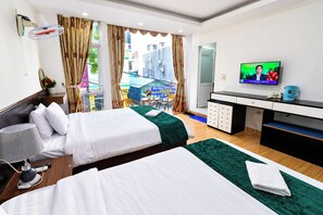 A hotel room with two beds, a desk, a TV, and a view of the outside. - Catba Island Hotel (Hai Phong)