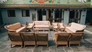 A traditional building with a courtyard featuring wicker furniture and a decorative mural. - Mountain Lodges of Nepal - Thame (Thame)