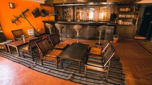 Una zona de bar con taburetes, una mesa larga y una barra.