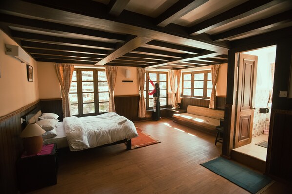 A room with a bed, a bench, and a door leading to another room. - Mountain Lodges of Nepal - Monjo (Monjo)