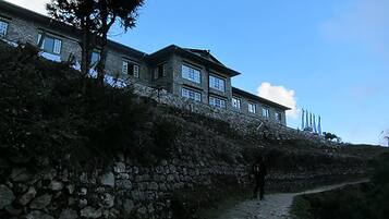 A stone building with multiple windows and a pathway leading up to it.