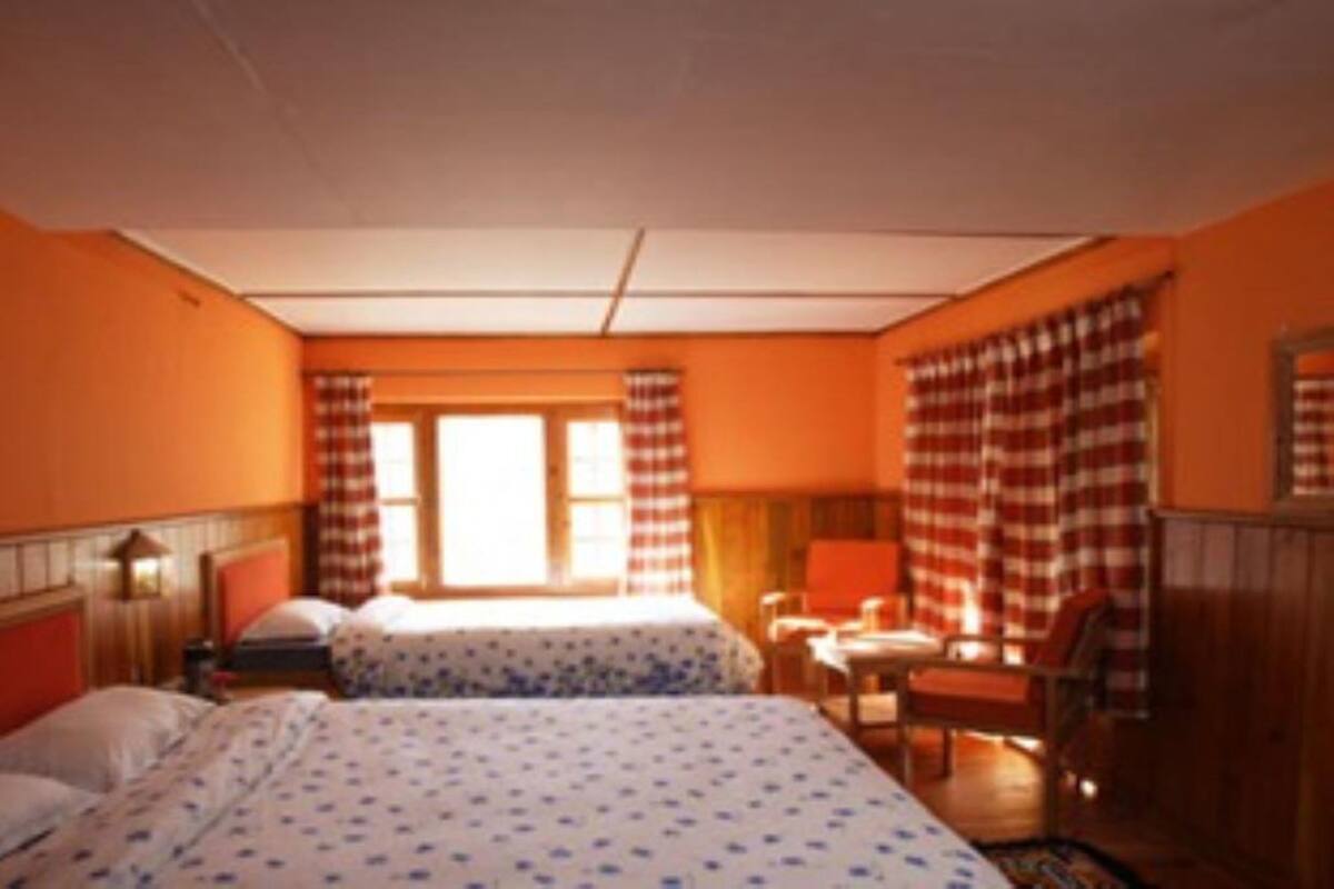 Een hotelkamer met twee bedden, een bureau en een stoel.