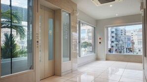 Un ascenseur moderne doté de portes en verre, d’un agencement intérieur épuré et offrant une vue sur la ville grâce à de grandes fenêtres.