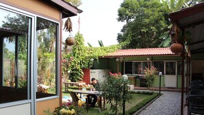 A patio area with a table and chairs, surrounded by potted plants and a small garden.