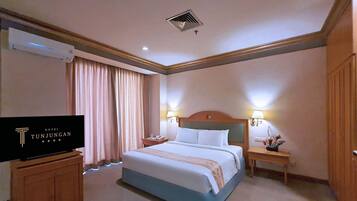 A hotel room with a bed, two bedside lamps, a nightstand, a TV, and a window with curtains.