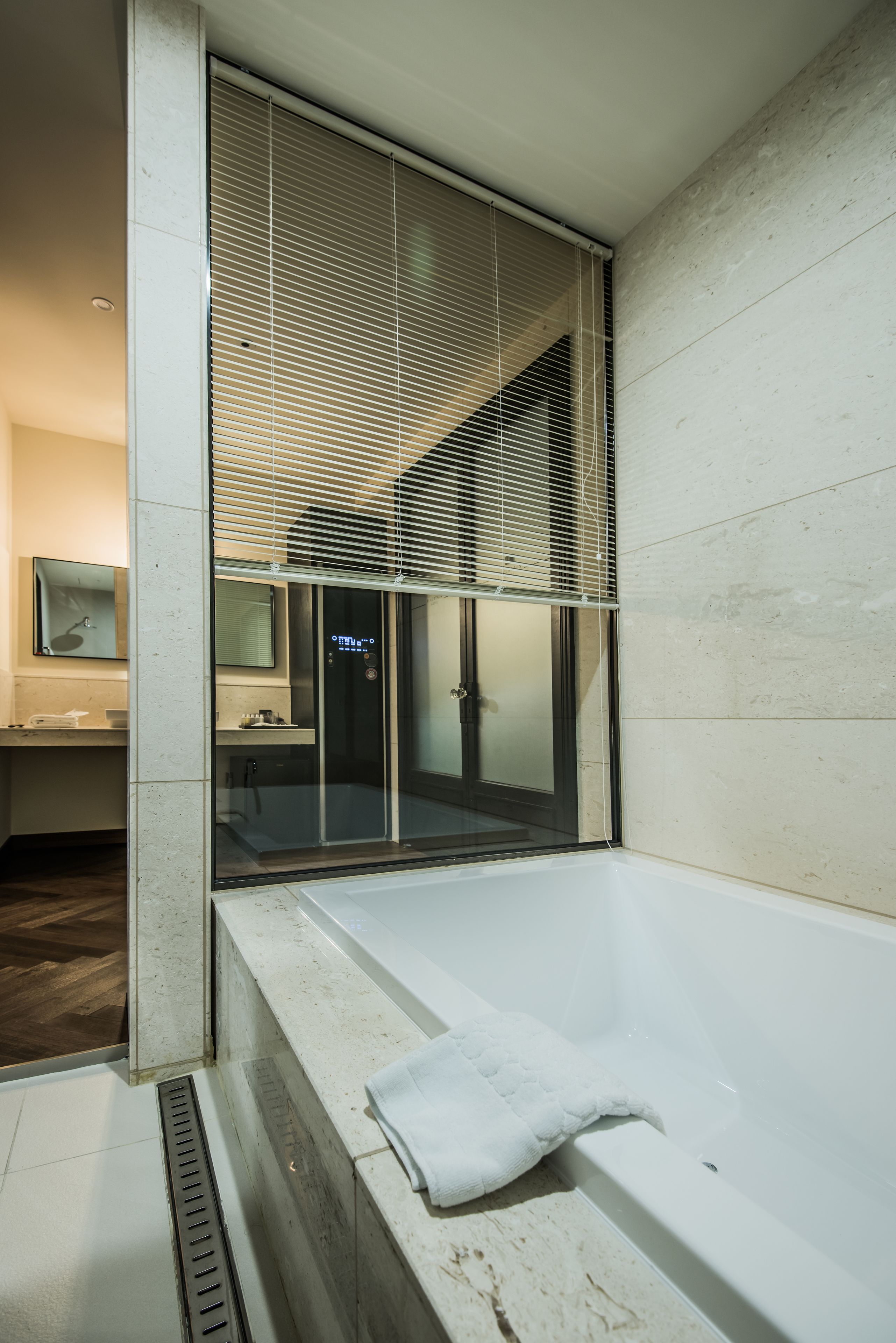 Un baño moderno con ducha de vidrio, bañera y tocador con espejo.