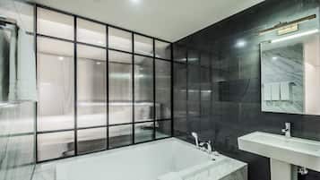 Suite | Badkamer | Een aparte badkuip en douche, een haardroger, badjassen, pantoffels