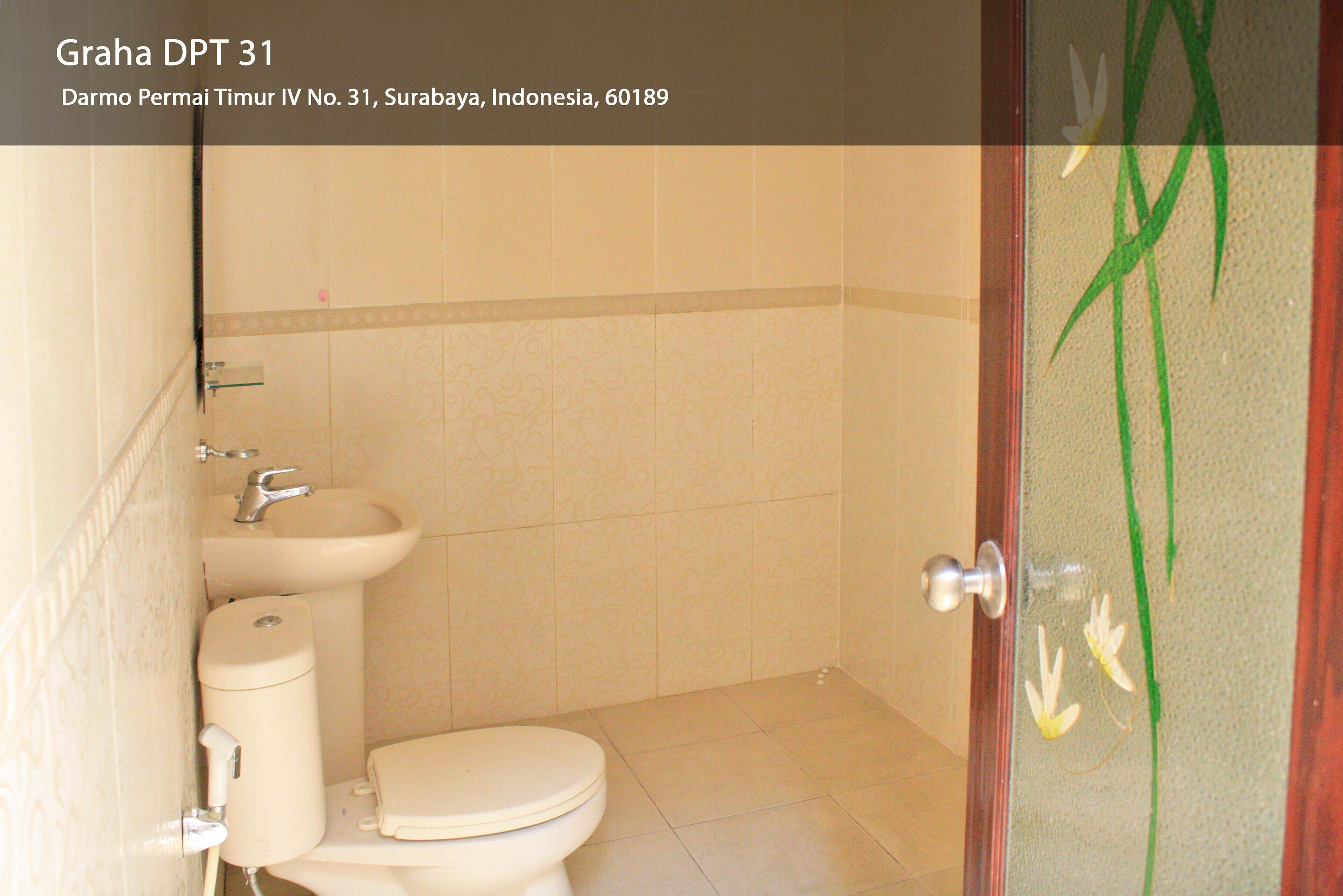 A bathroom with a toilet, sink, and a decorative door with floral patterns.