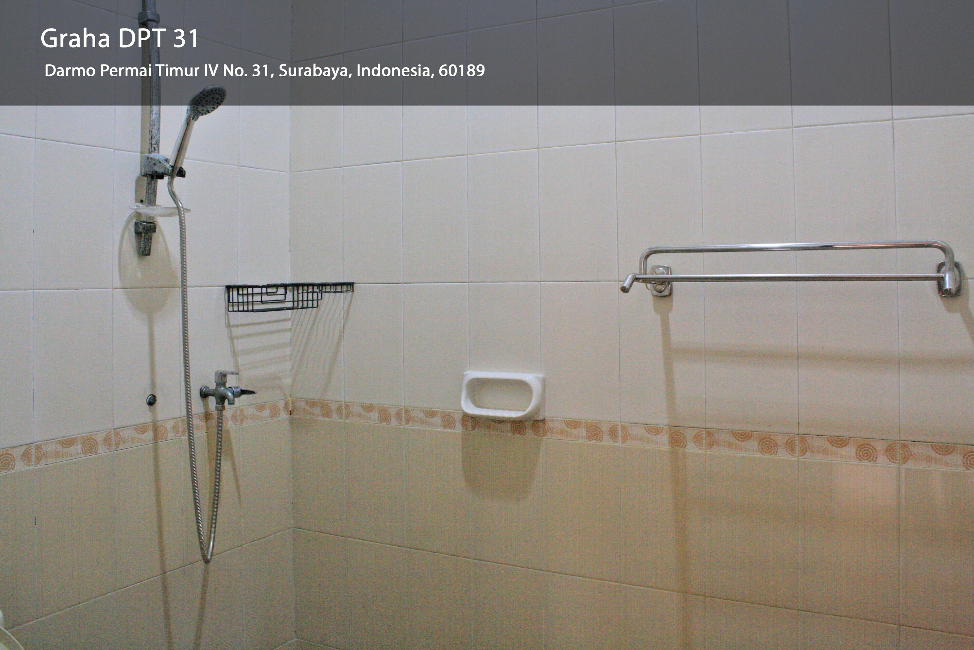 A bathroom with a shower, grab bar, and toilet.