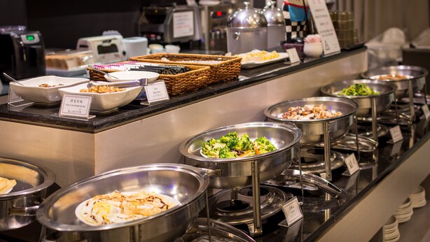 A buffet with various food options, including salads, meats, and desserts, arranged on a counter with serving utensils and labels. - Country Garden Hotel (Chiayi City)
