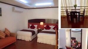 Quarto de hotel com duas camas, um sofá, área de refeições com mesa e cadeiras, banheiro com chuveiro e uma cozinha compacta.