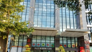 A modern building with large glass windows and signage indicating it is a medical facility. - Kaixin Express Hotel (Shenzhen)