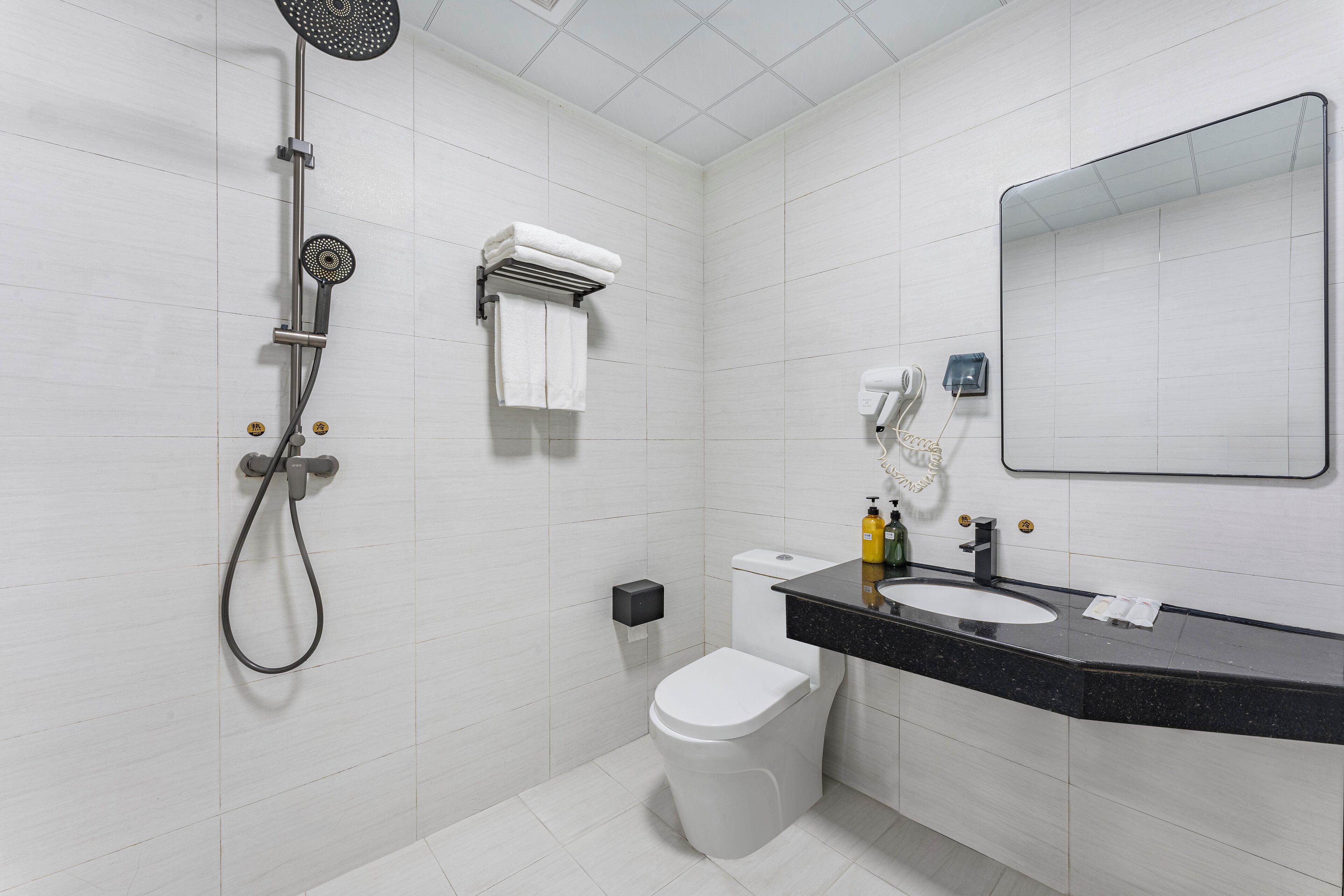 Un baño moderno con ducha, inodoro y lavamanos.