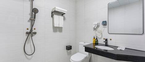 Un baño moderno con ducha, inodoro y lavamanos.