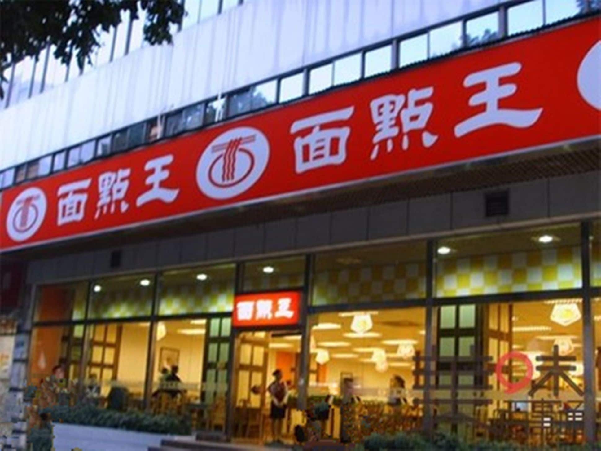 A building with a red sign that reads "面粉王" and a smaller sign above the entrance that says "百叶亭".