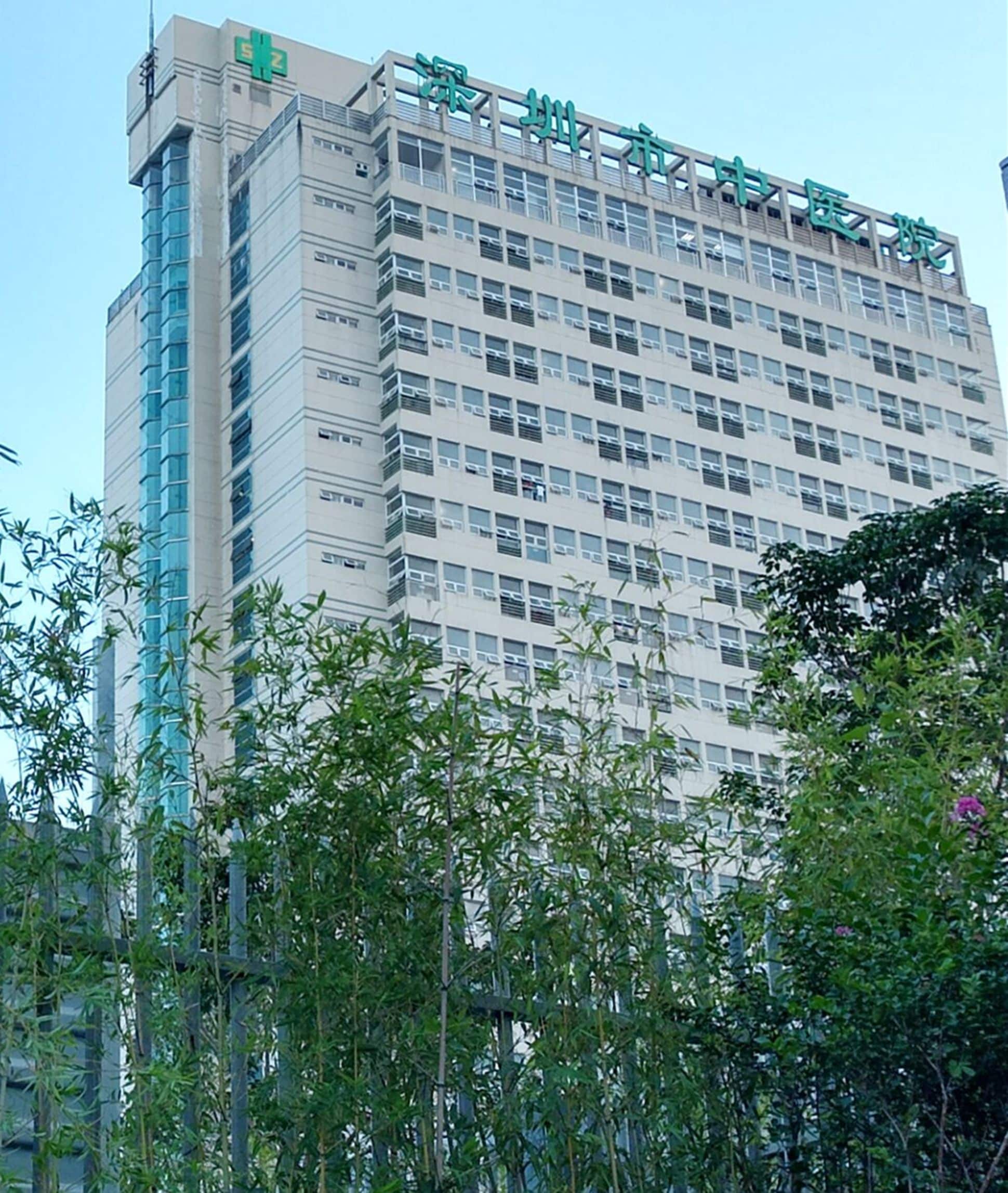 A multi-story building with a modern architectural design, featuring numerous windows and a prominent signage at the top.