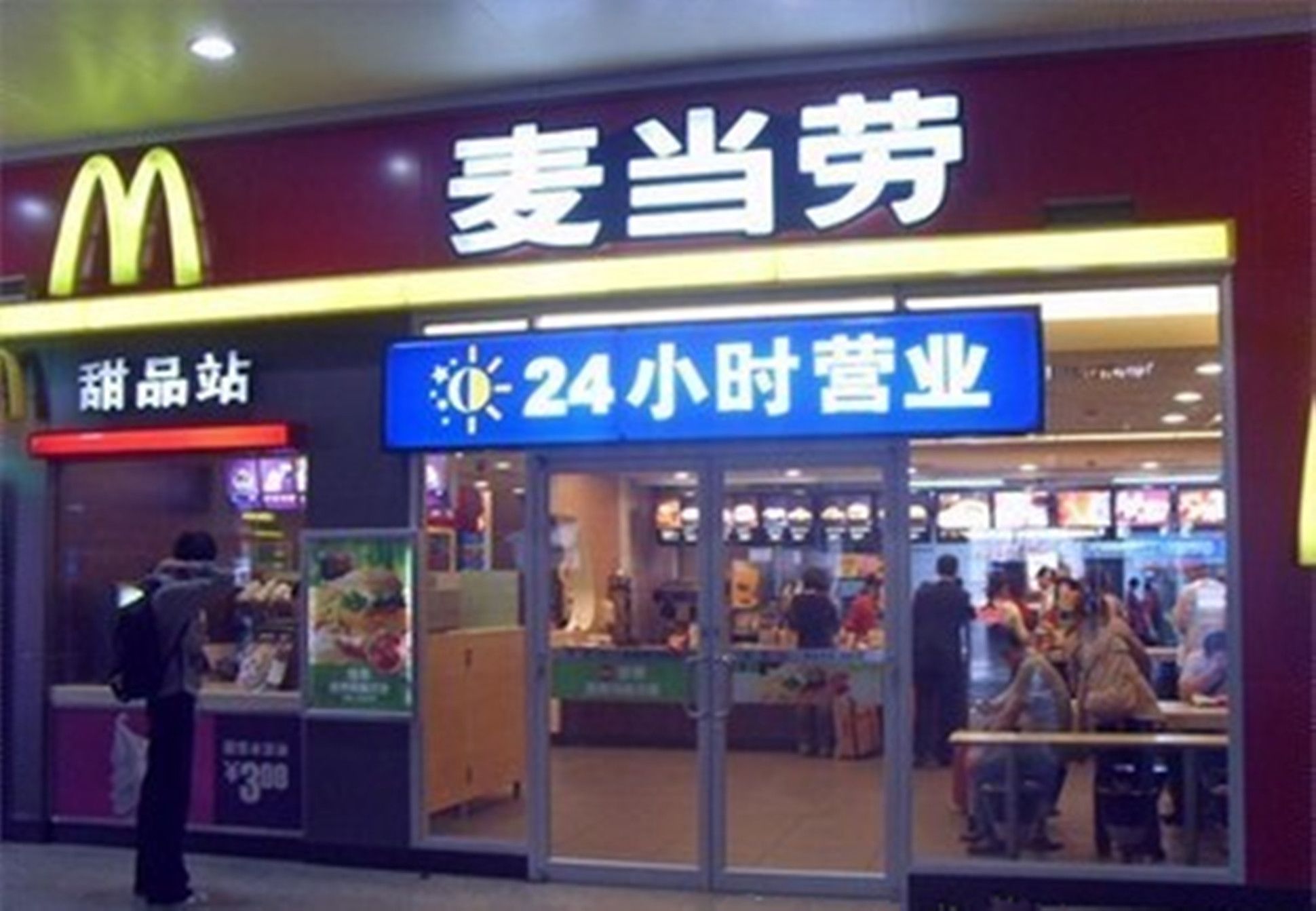 Een McDonald's restaurant met een bordje voor 24-uurs bediening.