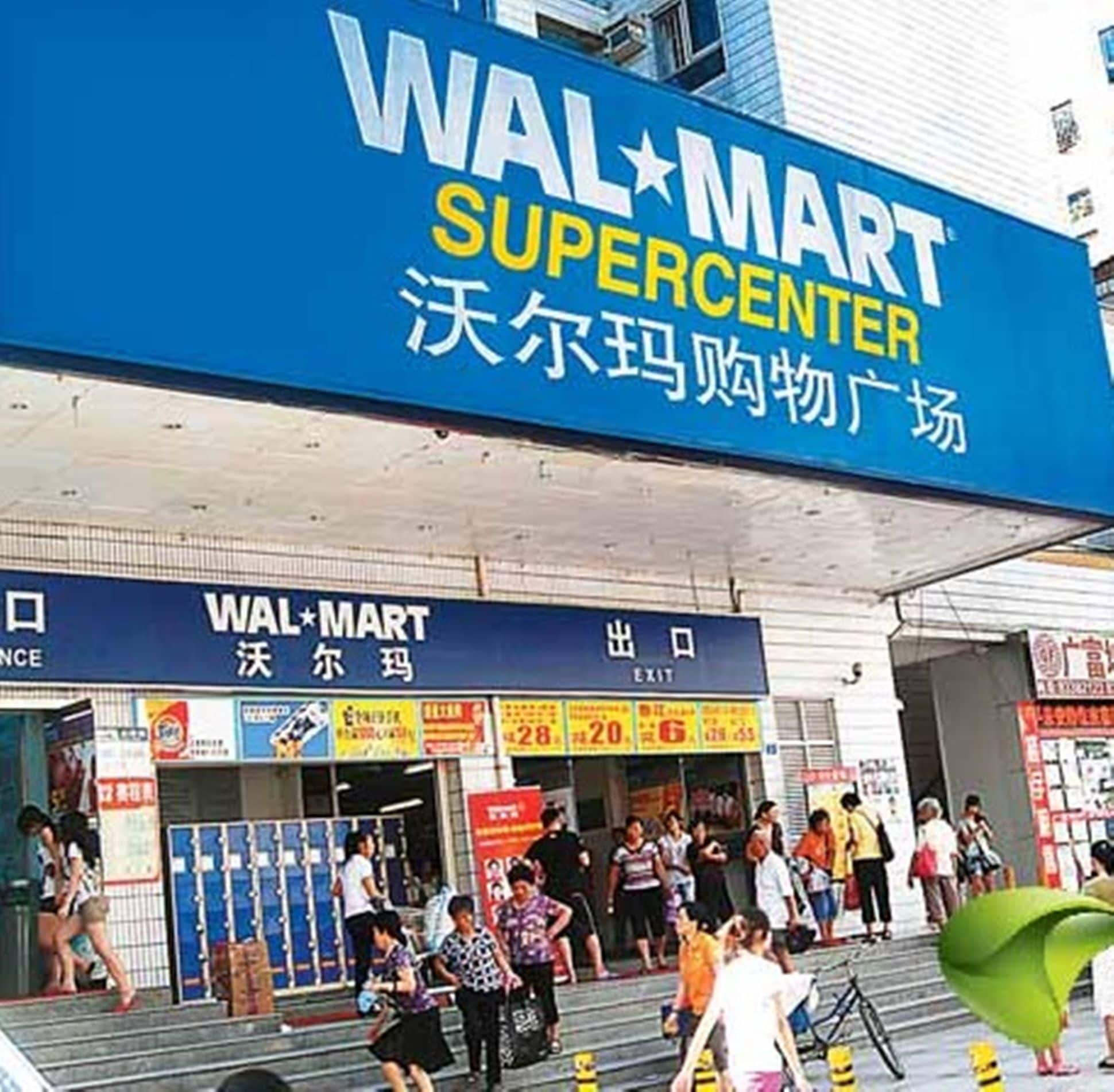 Een Walmart Supercenter met een groot blauw bord, meerdere ingangen en een menigte mensen voor de winkel.