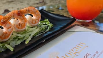 A menu with a shrimp dish and a drink.