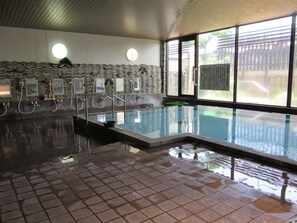 An indoor swimming pool with tiled flooring and a wavy wall design. - Yamaga Onsen Ryokan Hosokawa (Yamaga)