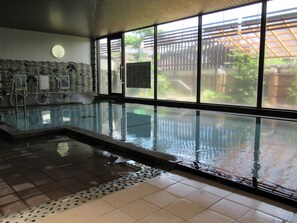 An indoor swimming pool with clear glass walls, a tiled floor, and a wooden ceiling. - Yamaga Onsen Ryokan Hosokawa (Yamaga)
