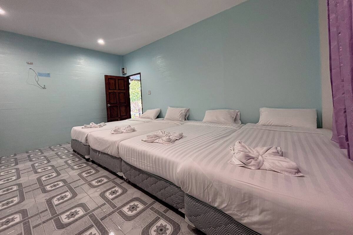 A hotel room with a large bed, a small table, and a patterned floor.