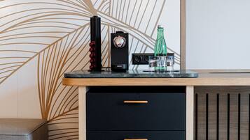 Eine moderne Küche mit Arbeitsplatte, einer Kaffeemaschine, einer Flasche und einer Schubladenkommode.