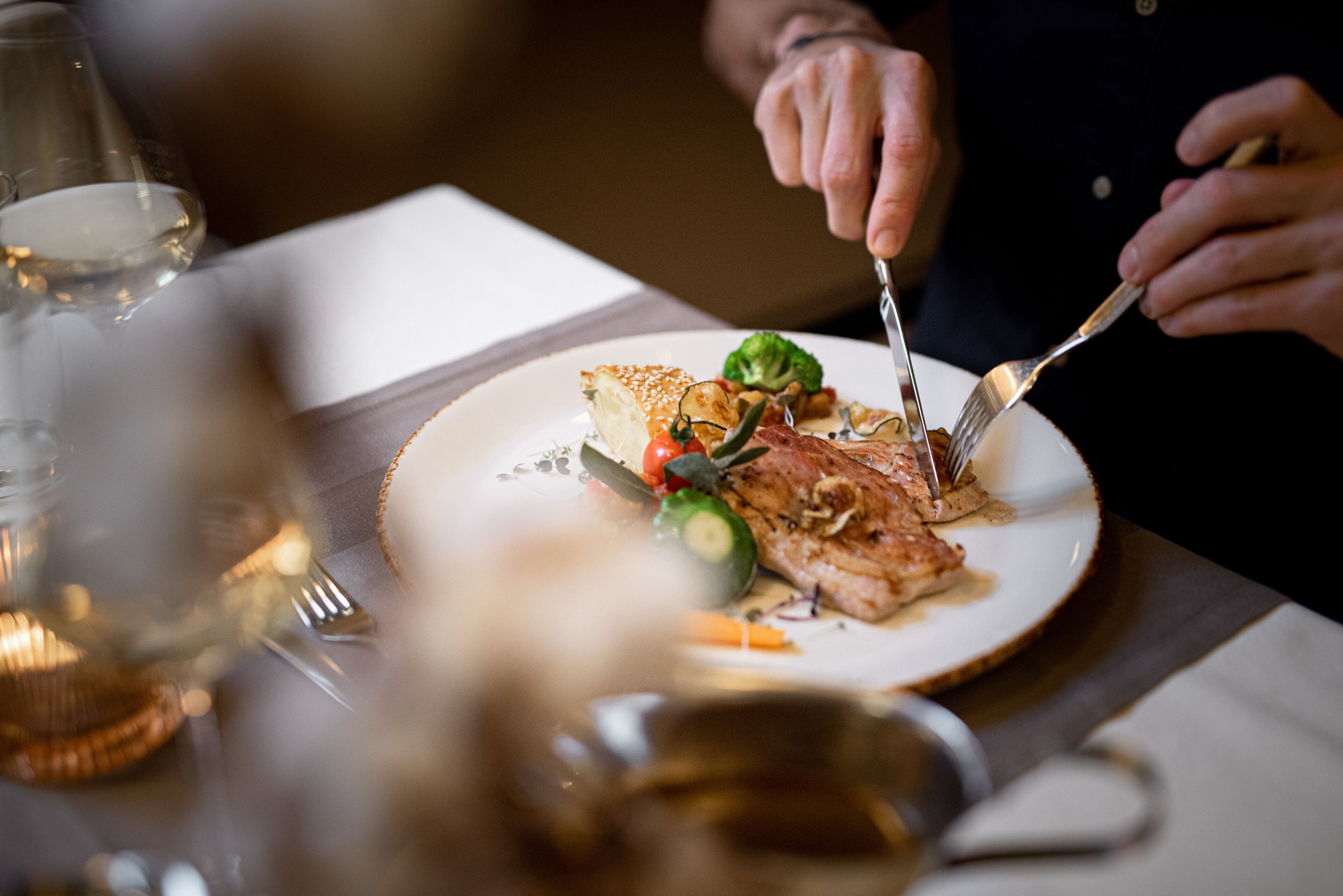 A dining table with a plate of food, a fork, and a knife.