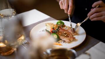 A dining table with a plate of food, a fork, and a knife.