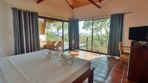 A bedroom with a bed, a television, and a view of the outdoors. - El Nido Overlooking Resort (El Nido)