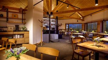 A cozy restaurant with wooden furniture and a bar area.